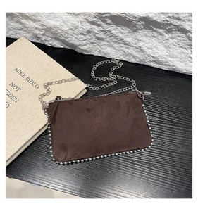 Macro view of brown frosted leather bag with silver metal bead edge and chain strap