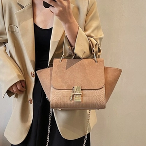 Detail of khaki wings bag showing contrast textures, crocodile pattern and gold twist lock