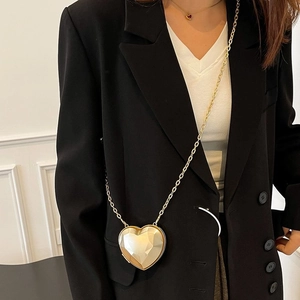 Fashionable gold heart-shaped crossbody bag with faceted geometric surface and chain
