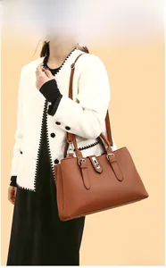 Close-up of brown litchi pattern leather tote bag with metal lock and stitching