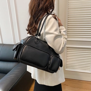 Detail of a black leather travel bag with large zipper and side magnetic flap pockets