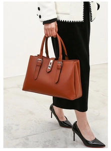 Close-up of caramel PU leather tote with pebble texture and silver metal buckle details