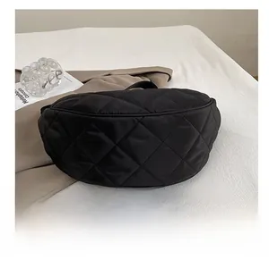 Dettaglio del fondo in nylon trapuntato resistente e cuciture della borsa nera a mezzaluna