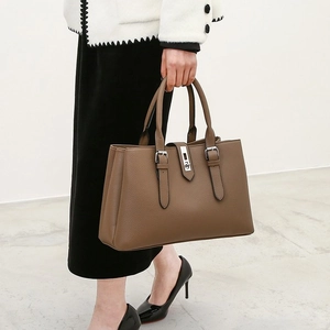 Detail of dark brown faux leather tote bag with stitch decor and metal buckle