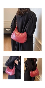Détail du sac à bandoulière vintage rouge semi-circulaire avec boucle en métal doré
