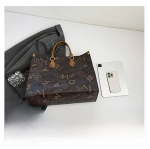 Close-up of vintage brown tote bag with letter print and business casual desktop items