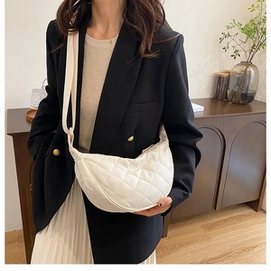 Modella con borsa a mezzaluna bianca trapuntata che mostra la dimensione reale e stile