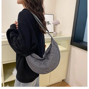 Dettaglio della borsa a mezzaluna grigia trapuntata con elegante trama in nylon lucido