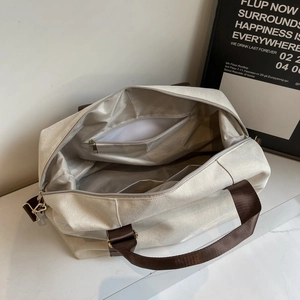 Spacious interior of beige canvas travel tote bag with brown straps and inner zipper pocket