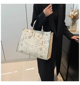Detail of white tote bag featuring black letter prints and khaki side paneling