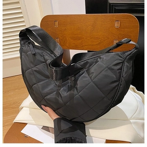 Dettaglio della borsa a mezzaluna in nylon nero con trama trapuntata a rombi