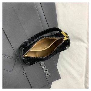 Black velvet cylinder handbag with gold hardware and interior lining detail shot