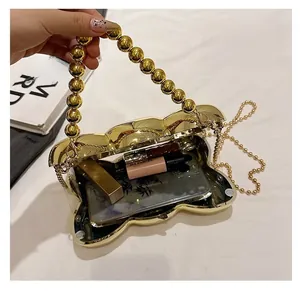 Détail de la pochette dorée en forme de coquillage montrant l'espace intérieur