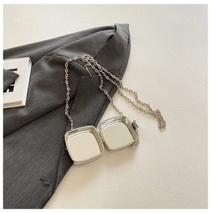 Silver square acrylic mini chain bag with mirror finish shown on grey blazer background