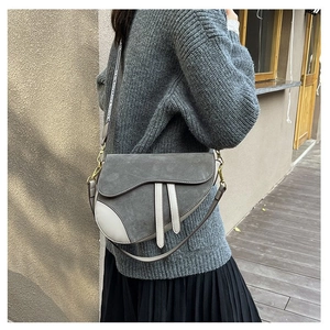 Close-up of saddle bag details with gray suede material and gold metal hardware