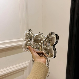 Détails d'un sac à main argenté en forme de papillon avec finition miroir et chaîne à perles