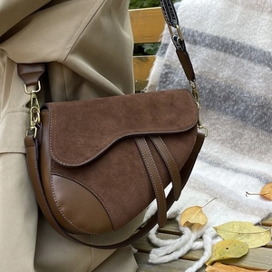 Brown suede saddle bag with wide embroidered shoulder strap and vintage hardware