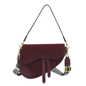 Burgundy saddle bag with matte flap and two adjustable shoulder straps on white background