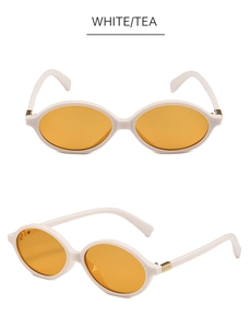 Detail view of oval white acetate frame glasses with brown lenses and gold stud accents