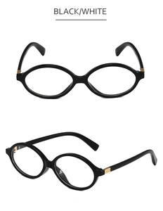 Detail view of oval black frame glasses showing golden hinge hardware and sleek profile