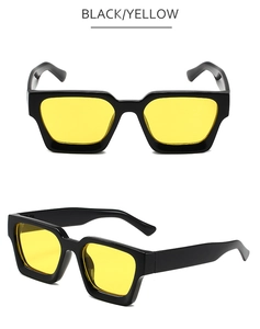 Détail de lunettes de soleil rétro carrées avec monture noire épaisse et verres jaunes