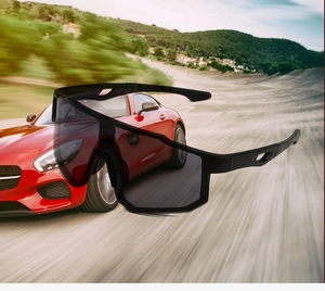 Dettaglio di occhiali da sole sportivi neri aerodinamici con sfondo di auto da corsa veloce