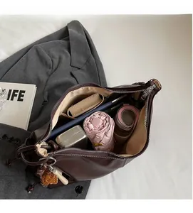 Detail view of large brown leather tote bag interior showing spacious capacity with daily items