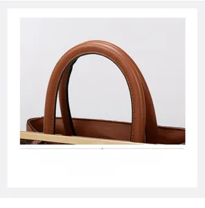 Close-up of brown lychee leather handbag featuring cylindrical handles and gold metal accents