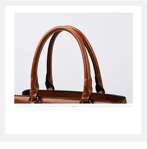Close-up of double handles and stitching details on a brown faux leather tote bag