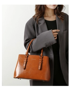 Detail of vintage brown glossy leather tote bag with elegant handles and fashion text