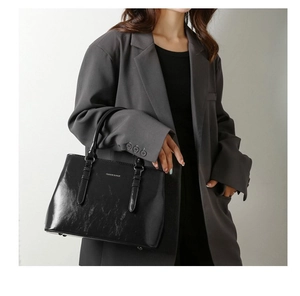 Close-up of black retro leather tote with polished oily finish and Fashion & Bag logo