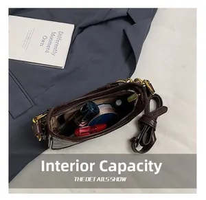 Capacité interne du sac croissant marron foncé montrant le rangement pour maquillage