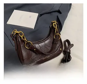 Détails du sac hobo en cuir huilé marron avec texture vintage et chaîne dorée