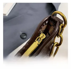 Détails du sac à main en cuir marron brillant avec chaîne dorée et doublure écossaise