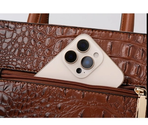 Detail of brown crocodile pattern handbag with back zipper pocket for smartphone storage