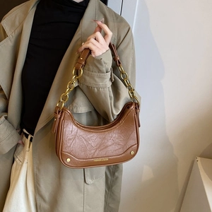 Gros plan du sac demi-lune marron en cuir plissé rétro avec détail chaîne dorée