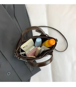 Vue de dessus du grand intérieur d'un sac à main en cuir brillant marron avec accessoires
