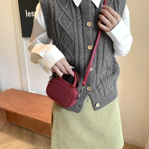 Minimalist red mini crossbody bag styled with autumn outfit in a cozy interior