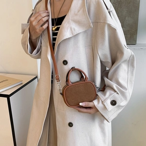 Close-up of caramel stitching mini bag with matte suede texture and cylinder handle