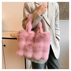 Detail shot of a soft pink faux fur tote bag showing the thick plush texture on model