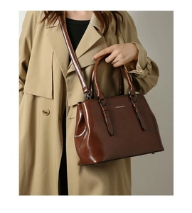 Brown glossy shoulder bag with gold Fashion & Bags logo worn with a beige trench coat