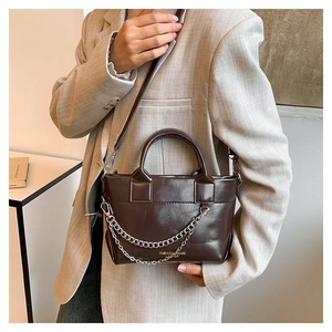Détail du sac en cuir marron café avec chaîne argentée et logo FASHION BAGS