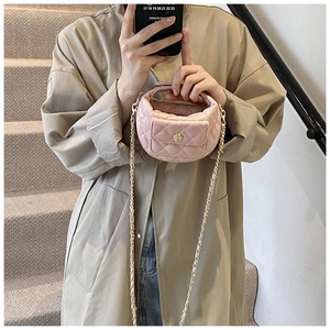 Dettaglio mini borsa a tracolla rosa trapuntata con chiusura floreale dorata