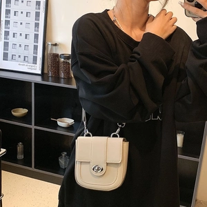 Chic cream-white crossbody bag featuring a classic flap and silver rotary lock on a model