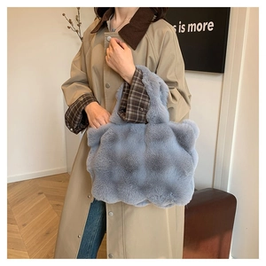 Detailed view of the plush blue-gray tote bag featuring a textured bubble faux fur finish