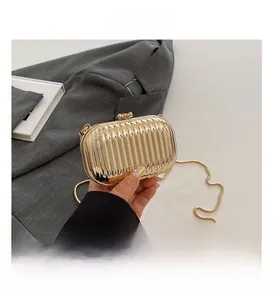 Detailed macro view of golden evening clutch with vertical texture and metallic chain strap