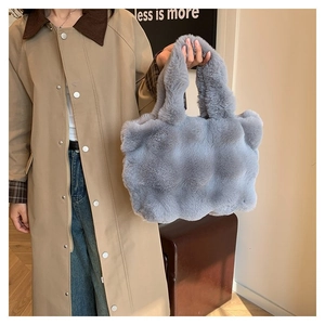 Detail of grey plush faux fur tote bag with textured plaid pattern for winter fashion