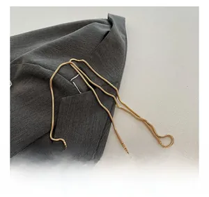 Detailed close-up of premium golden metal chain strap on a metallic party evening bag