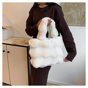 Detail shot of white plush tote bag featuring unique wavy faux fur texture and soft handles