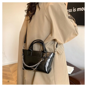 Détail du sac à main en cuir brillant noir avec chaîne argentée et imprimé FASHION BAGS